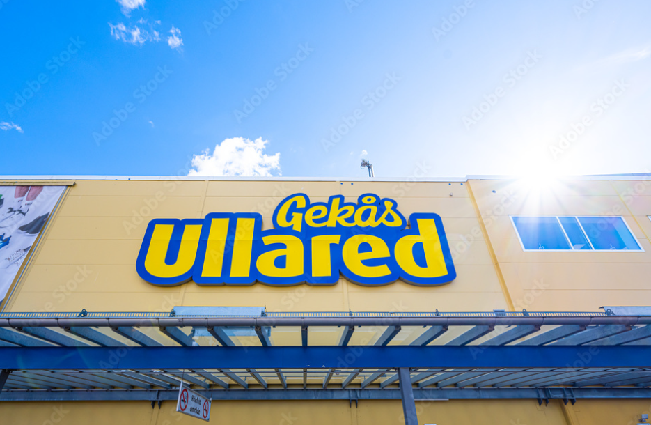 Bildens visar fasaden av Ullareds varuhus i Gekås. Himlen är klarblå och solen ligger på.